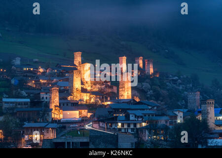 Vue sur les tours de Svanetian avec éclairage de nuit à Mestia ville contre les montagnes de neige , Upper Svaneti, Géorgie Banque D'Images