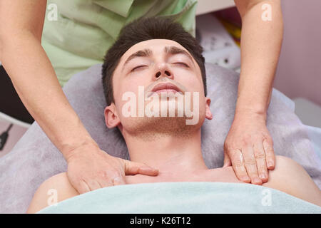 Jeune homme ayant massage. Client de masseuse. Banque D'Images