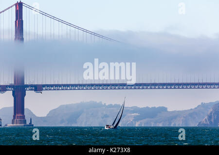 Brouillard sur la travée du pont du Golden Gate se dirige vers la ville comme voilier passe par Banque D'Images