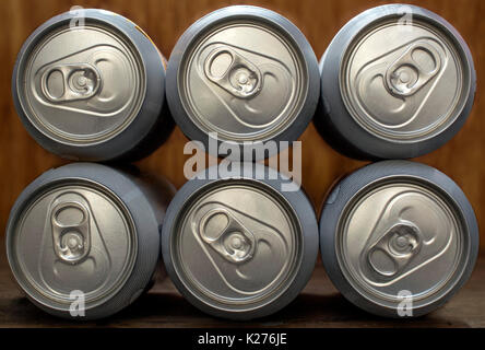 6 bière ou soda organisé frontale en aluminium argenté, sur un fond de bois Banque D'Images