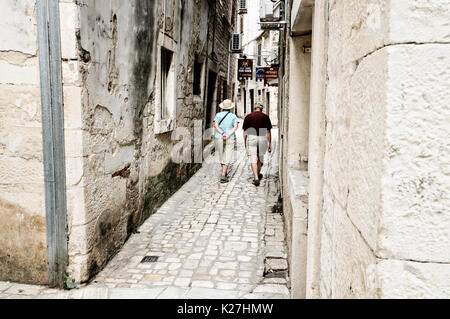 Couple de personnes âgées marchant dans la vieille ville historique de Trogir, Croatie Banque D'Images