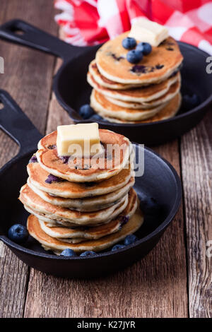 Crêpes de bleuets frais garni de beurre dans la poêle en fonte pour le brunch romantique servi sur table rustique Banque D'Images