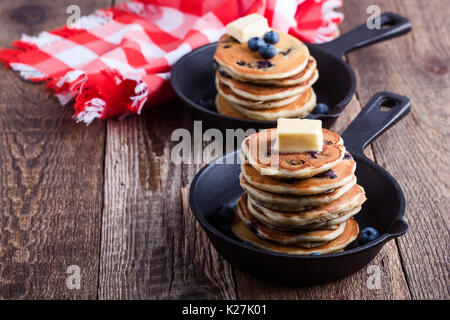 Crêpes de bleuets frais garni de beurre dans la poêle en fonte pour le brunch romantique servi sur table rustique Banque D'Images