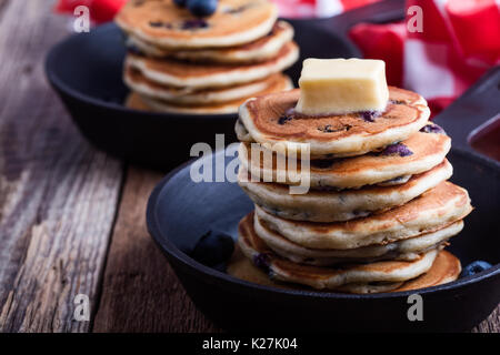 Crêpes de bleuets frais garni de beurre dans la poêle en fonte pour le brunch romantique servi sur table rustique Banque D'Images