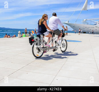 Les touristes sur un vélo tandem le long du front de mer. Banque D'Images