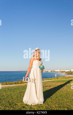 Bride holding bouquet et du mot amour Banque D'Images