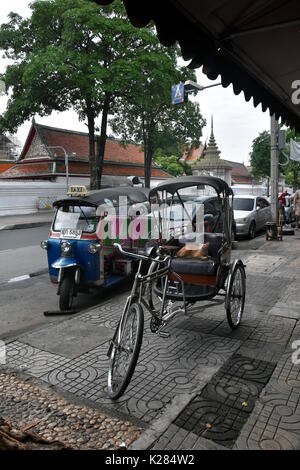 Taxi à trois roues célèbre en Thaïlande - moto tuk tuk. Machine à moteur GNC. Un chat roux est assis dans l'un tuktuk. Banque D'Images