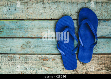 Tongs en caoutchouc bleu sur un fond de bois. Banque D'Images