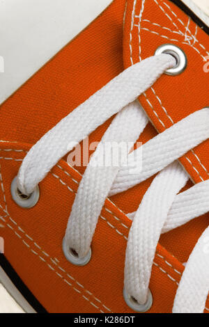Le laçage sur une sneaker rétro, close-up, sur un fond en bois bleu. Banque D'Images