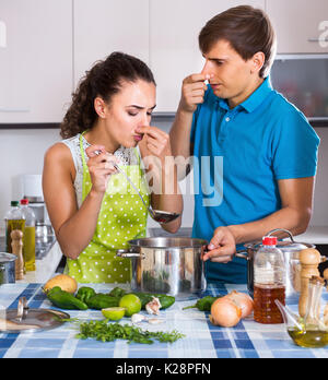 Couple malheureux avec légumes puant la nourriture en cuisine domestique Banque D'Images