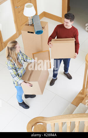 Jeune couple Carrying Boxes sur partir à jour Banque D'Images