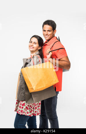 Indian heureux et jeune couple with shopping bags, homme et femmes asiatiques holding shopping bags, isolé sur fond blanc Banque D'Images