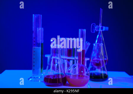 En chimie liquide coloré situé sur une table sur fond bleu Banque D'Images