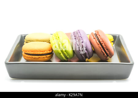 Macarons sucrés dans une plaque noire sur fond blanc Banque D'Images