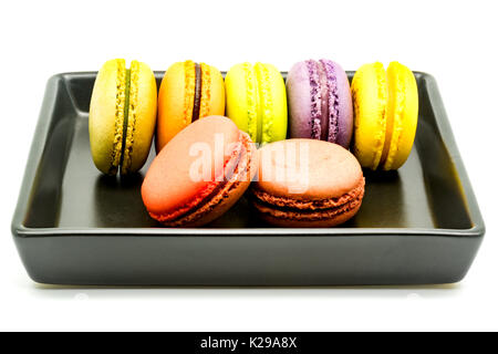 Rangée de macarons dans une plaque noire sur fond blanc Banque D'Images