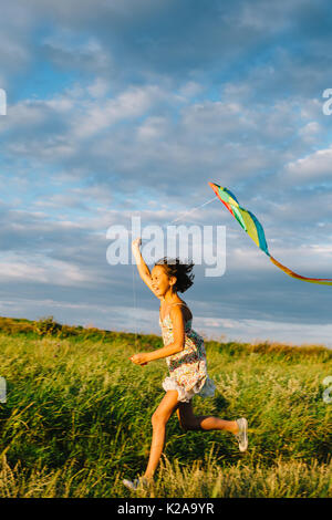 Cheerful girl running with kite Banque D'Images