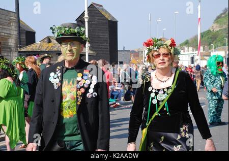 Les gens costumés à pied le long du front de mer par le stade au cours de l'Assemblée Jack in the green festival à Hastings, Angleterre le 5 mai 2014. Banque D'Images