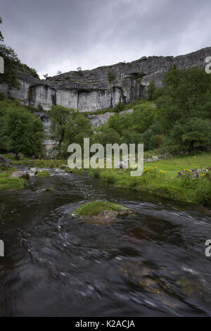 Vue panoramique sur soirée d'été de l'eau tourbillonnante de Malham Beck et l'anse, une immense falaise de calcaire et courbes - Malhamdale, Yorkshire, Angleterre, Royaume-Uni. Banque D'Images