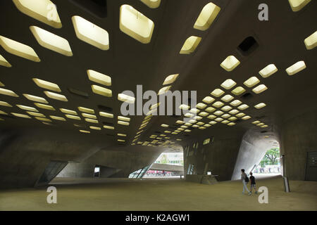 Les gens à pied sous le phaeno Science Centre conçu par l'architecte britannique d'origine irakienne Zaha Hadid à Wolfsburg, Basse-Saxe, Allemagne. Banque D'Images