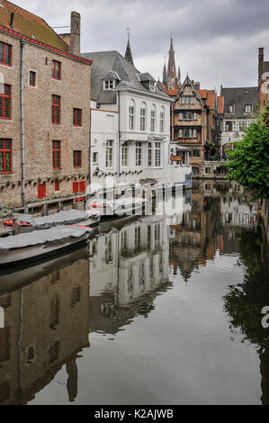 Les bâtiments médiévaux de l'ancienne ville de Brugge / bruges reflétée dans un canal tranquille avec bateaux amarrés en Flandre occidentale, Belgique Banque D'Images