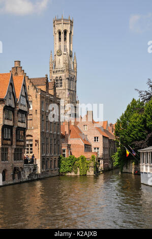 L'horizon de la ville médiévale de brugge / bruges en Flandre occidentale, Belgique avec l'eau d'un canal et de l'imposant beffroi de la place du marché Banque D'Images