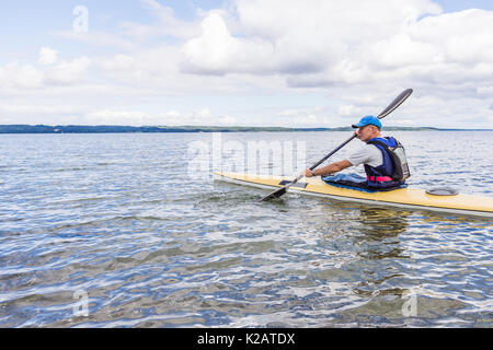 L'homme est une pagaie kayak jaune seul dans la baie, Holl, le Danemark, le 27 août 2017 Banque D'Images