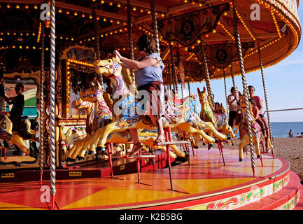 Vue estivale sur le front de mer de Brighton en août 2017 - les gens montent sur le carrousel Banque D'Images