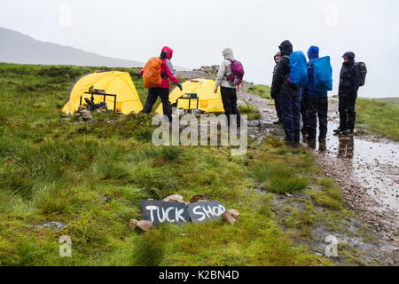 Les randonneurs en pluie battante par Tuck Shop tentes sur West Highland Way chemin sentier point le plus élevé en haut de l'Escalier de diables. Glen Coe, Highland, Scotland, UK Banque D'Images