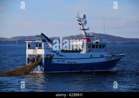 Bateau de pêche Océan 'Harvest' travaillant dans des conditions calmes Fair Isle dans la distance. Mer du Nord, au Royaume-Uni, en août 2014. Parution de la propriété. Tous les non-usages de rédaction doivent être effacés individuellement. Banque D'Images