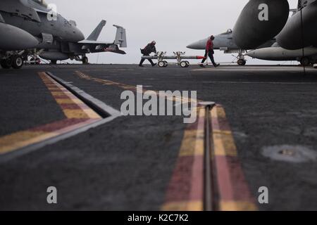 Les marins américains et des munitions sur le transport d'envol à bord de la marine américaine de classe Nimitz porte-avions USS Theodore Roosevelt Le 14 août 2017 dans l'océan Pacifique. Banque D'Images