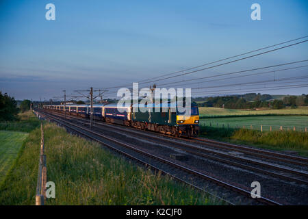 La 2350 London Euston - Glasgow et Édimbourg Caledonian sleeper Plumpton passe (au nord de Penrith) tiré par une locomotive électrique de la classe 92 Banque D'Images