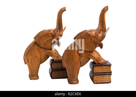 Deux vieux vintage marron en bois sculpté avec les détenteurs des éléphants a soulevé des troncs et bouche ouverte debout sur des livres avec les pattes de devant sur white isolés Banque D'Images