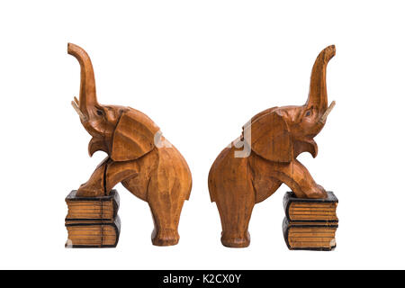 Deux vieux vintage marron en bois sculpté avec les détenteurs des éléphants a soulevé des troncs et bouche ouverte debout sur des livres avec les pattes de devant sur white isolés Banque D'Images