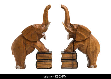 Deux vieux vintage marron en bois sculpté avec les détenteurs des éléphants a soulevé des troncs et bouche ouverte debout sur des livres avec les pattes de devant sur white isolés Banque D'Images