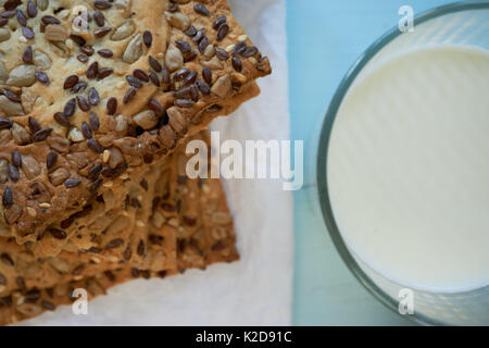 Libre de cookies frais couverts de diverses graines chia, sésame, tournesol avec verre de lait Banque D'Images