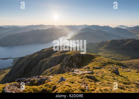 Sunstar et les rayons de lumière sur le Loch Hourn et Barrisdale bay après le lever du soleil. Knoydart, Highlands, Écosse, Royaume-Uni, juin 2016. Banque D'Images