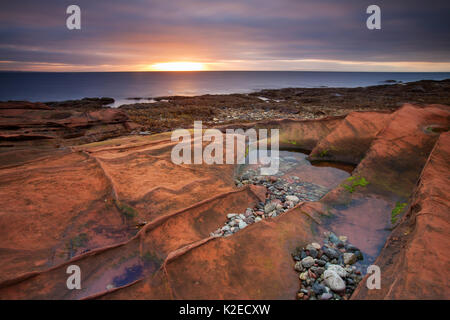 Rochers de grès et le littoral au lever du soleil près de Corrie, Isle of Arran, Ecosse, Royaume-Uni, octobre 2013. Banque D'Images