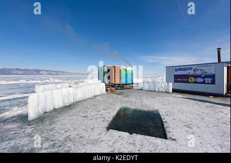 Trou dans la glace (ou Maina) pour la plongée sous glace, et sauna. Le lac Baïkal, Sibérie, Russie. Banque D'Images