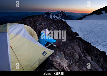 Femme camping sur le bord du cratère du sud de soeur, trois Sœurs, Désert, forêt nationale de Deschutes. De l'Oregon, USA, juillet 2014. Parution du modèle. Banque D'Images