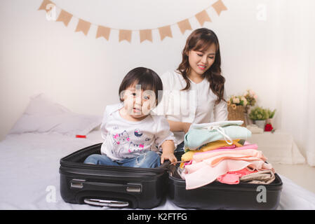 Asian maman et bébé fille avec des vêtements et bagages valise prête pour voyager en vacances Banque D'Images