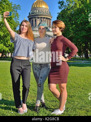 Trois jeunes filles font sur smartphone selfies sur l'arrière-plan de St. Banque D'Images