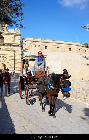 Horse carriage crossing et la porte de la ville passerelle, Mdina, Malte, l'Europe. Banque D'Images