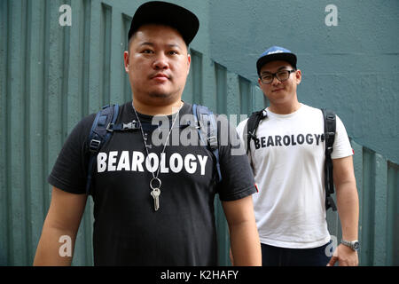 Deux hommes gay dans les rues de Hong Kong, l'ours style avec cap Banque D'Images