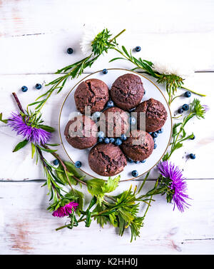 Vue de dessus d'une table en bois blanc avec des muffins et diverses décorations sur elle. Banque D'Images