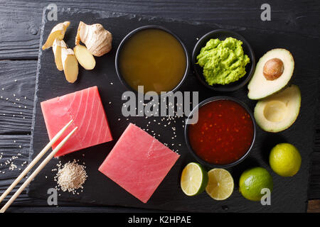 Cuisine japonaise : steak de thon cru avec des ingrédients pour la cuisine gros plan sur la table. Vue de dessus d'au-dessus de l'horizontale Banque D'Images