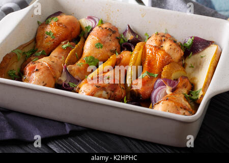 Pilons de poulet cuit avec du miel poires et l'oignon rouge gros plan sur la table horizontale. Banque D'Images