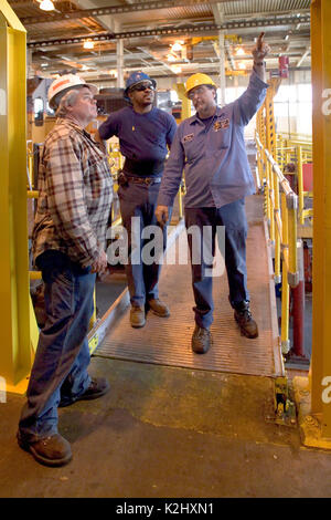 African American and Caucasian railroad accidents entretien recevoir des instructions de leur patron à une gare de marchandises ferroviaire hangar de réparation à Roseville, CA. Communiqué de modèle Banque D'Images