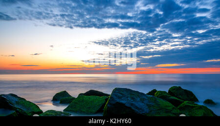 Photo a été prise à Avon by the sea beach pendant heure bleue, montrant belle gamme de couleurs. Plage avec un beau ciel nuageux et de pierres Banque D'Images