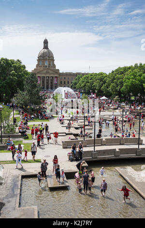 Adultes et enfants jouant dans les fontaines d'eau à l'Assemblée législative de l'Alberta, Alberta, Canada Banque D'Images