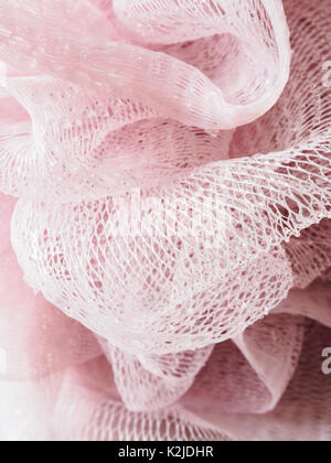 En plastique rose loofa hygine scrubber couvertes de gouttes d'eau Banque D'Images